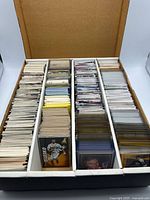 Overview of four-row box filled with assorted sports cards