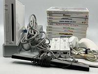 Console, controllers, sensor bar, cables and stack of nine Wii game cases