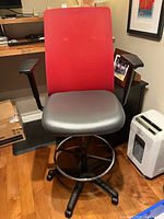 Front view showing red mesh back, grey seat, armrests, base