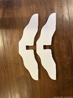 two removable curved white wooden support feet