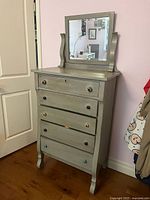 Front view showing five drawers, attached mirror, colourful knobs