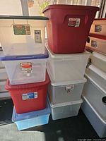 Stack of eight plastic storage totes showing sizes and colors
