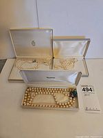 Three pearl necklaces in presentation boxes showing overall lot