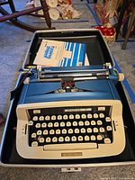Royal portable manual typewriter inside open hard case with booklet visible