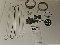 All jewelry pieces laid out including necklaces, bracelets and pins