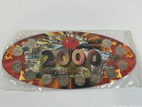 Front view of oval display card showing all twelve coins and 2000 graphics