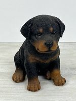 Front view of seated resin Rottweiler puppy figurine