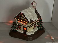 Front view showing house, trees, Santa, cord lit