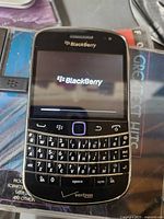 Front view showing keyboard, screen booting with BlackBerry logo and Verizon mark