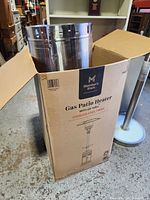 Manufacturer box marked Member's Mark Gas Patio Heater with LED Table, top open showing parts