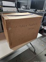 Closed carton labeled 'Shoe Covers XL 100/pk'