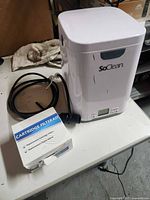 SoClean 2 cleaner with hose and filter kit box on table