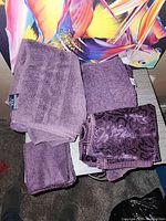 Stacks of purple towels, mix of solid and patterned pieces