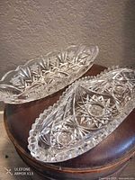 Both cut crystal oblong dishes on surface