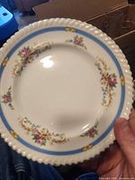 Front view of ivory plate with blue band and floral garland