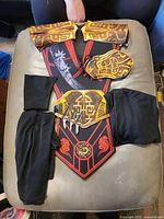 All pieces laid out showing tabard, armor plates, bracers and fabric covers
