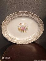 Front of porcelain platter showing floral centre and gold-trimmed scalloped rim