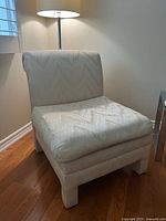 Front view of upholstered accent chair showing seat, back, and block legs