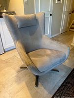 Front left view of light grey swivel armchair, showing upholstery and base