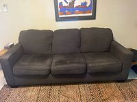 Front view of dark grey three-cushion sofa
