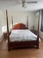 Front view of assembled queen four-poster bed frame with box spring