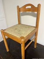 Front angle view of wooden chair with woven seat