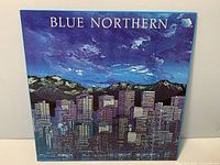 Front jacket showing Blue Northern cityscape artwork