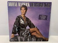 Front cover of Dionne Warwick Heartbreaker LP showing hype sticker and light edge wear