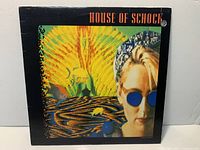 Front cover of House of Schock LP showing artwork and drill hole