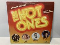 Front of The Hot Ones compilation sleeve showing title, artists, wear present