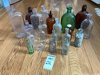 Full group of approximately 20 vintage glass bottles on floor