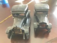 Front view of both cast iron cars showing grille difference and paint wear