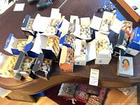 Overall lot view showing approximately 20 boxed Hummel figurines on table