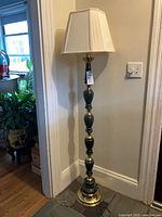 Entire floor lamp with shade against wall