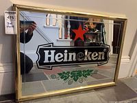 Angled front view of complete Heineken mirror in frame