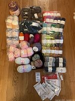 Overview of all yarn skeins, bags and circular needles on floor