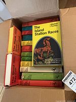 Open box with stack of Walter Farley hardcover books, top book The Island Stallion Races visible