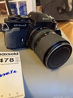 Angled front view of Ricoh KR-5 Super II camera with zoom lens attached