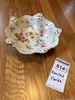 Top view showing floral design, pierced handles, gold trim