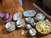 Overview of plates, serving pieces, teapot, cup storage, protective quilted carriers