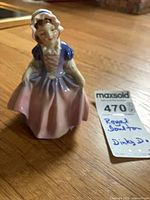 Full view of figurine standing on wood surface