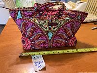 Front view of Vera Bradley quilted tote with measuring tape showing width, hang tag visible