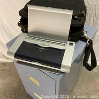 Canon Pixma iP90 printer on cabinet with case