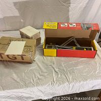 Boxed Brutus tile cutter beside stacks of cream ceramic tiles