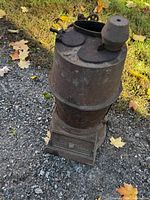 Full view of stove showing rusted surface and overall form