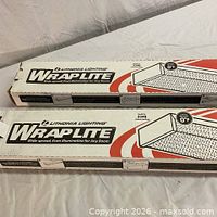 Two boxed Lithonia WrapLite fixtures front view