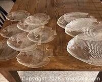 Overview of all clear glass fish plates and platters on table