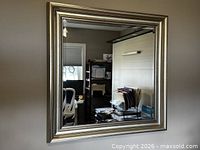Front view of square mirror showing metallic frame and reflection