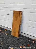 Front view of entire live edge board leaning against garage door