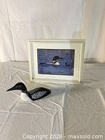 Framed loon photograph and carved wood loon together